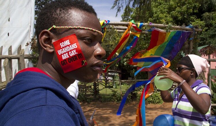 Hombre con una calcomanía que dice "Algunos ugandés son homosexuales, supéralo"