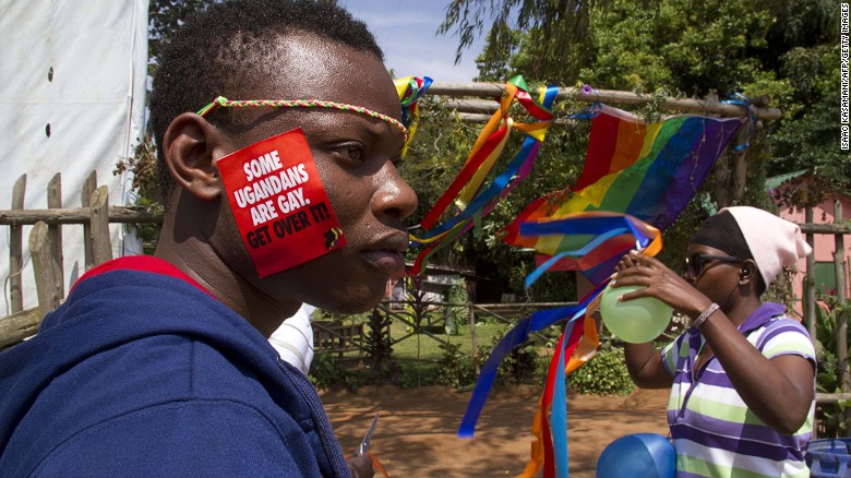 Hombre con una calcomanía que dice "Algunos ugandés son homosexuales, supéralo"