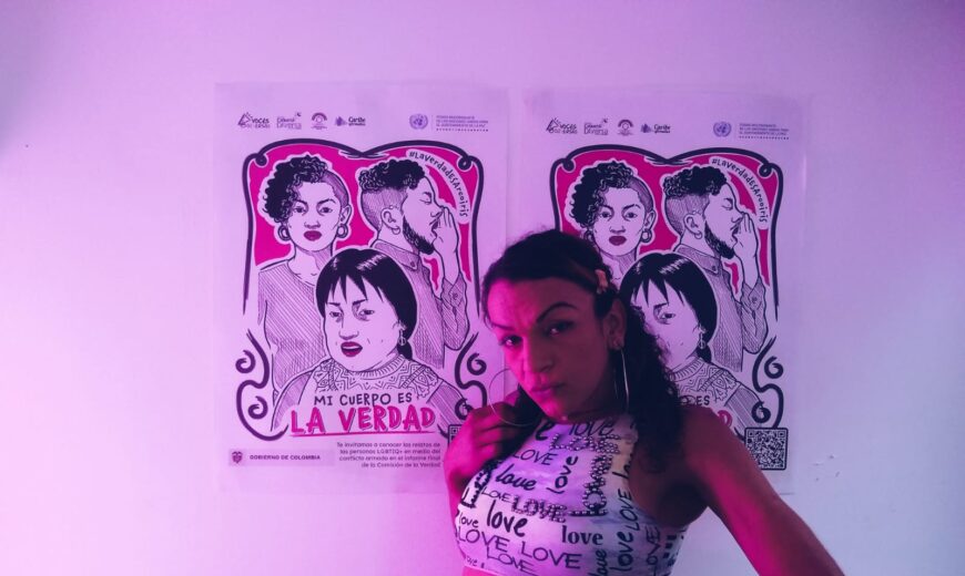 Mujer trans posa frente a carteles de la Comisión de la Verdad