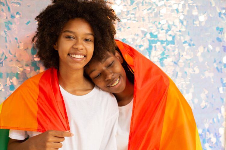 Pareja de mujeres negras con bandera LGBTIQ+