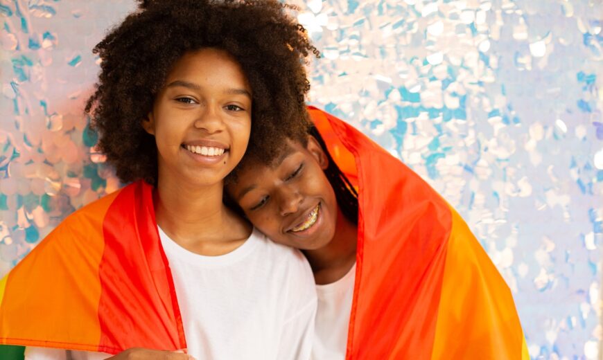 Pareja de mujeres negras con bandera LGBTIQ+